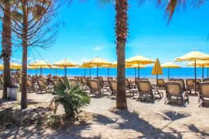 a group of chairs and umbrellas on a beach at 214 The Coastal Nest in Durrës
