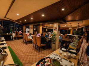 a restaurant with people sitting at tables in a room at Hotel Aachman Regency with Rooftop Terrace in Shimla