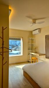 a bedroom with a bed and a desk and a window at SoSi Stay in Seoul