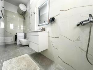 a white bathroom with a sink and a mirror at 214 The Coastal Nest in Durrës +14 photos