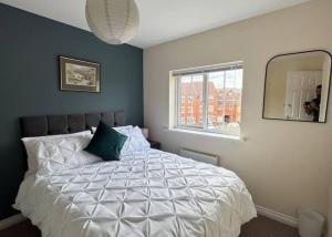 a bedroom with a white bed with a mirror at Gem Relax in Leighton Buzzard