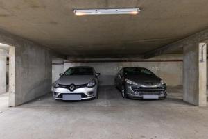 two cars are parked in a parking garage at DUPLEX SUBLIME ET LUMINEUX au CENTRE VILLE 10 minutes de Paris Parking privée souterrain in Rueil-Malmaison
