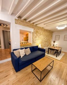 a living room with a blue couch and a table at DUPLEX SUBLIME ET LUMINEUX au CENTRE VILLE 10 minutes de Paris Parking privée souterrain in Rueil-Malmaison