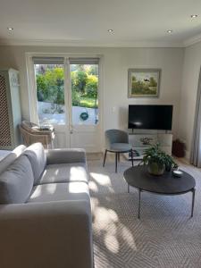 ein Wohnzimmer mit Sofa und Tisch in der Unterkunft Francolin Studio in Kapstadt