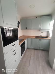 a kitchen with white cabinets and a wooden floor at SUNSHINE GROUP in Málaga