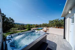 a hot tub on the patio of a house at Holiday House Roza in Vela Luka