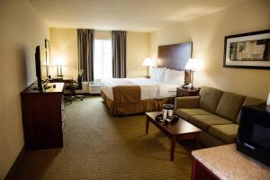 a hotel room with a bed and a couch at Cobblestone Hotel & Suites - Knoxville in Knoxville