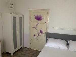 a bedroom with a bed and a door with a flower on it at Klancic 10 in Novi Vinodolski