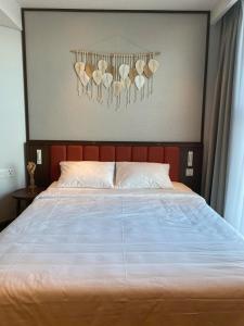 a bedroom with a bed with a headboard with seashells on it at The Seafront Condotel - Apec Mandala in Mui Ne