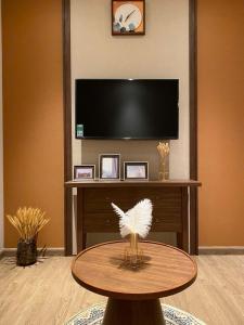 a living room with a table and a flat screen tv at The Seafront Condotel - Apec Mandala in Mui Ne +178 photos