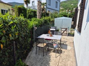 a patio with a table and chairs in a backyard at A & B apartment in Lovran +8 photos
