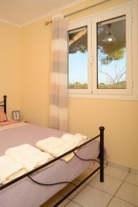 a bedroom with a bed and a window at CouCouNaries in Nisís Ánidhro