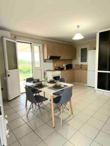 a kitchen with a table and chairs in a room at CouCouNaries in Nisís Ánidhro