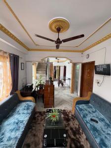 a living room with couches and a ceiling fan at The Basecamp Dorm in Siliguri