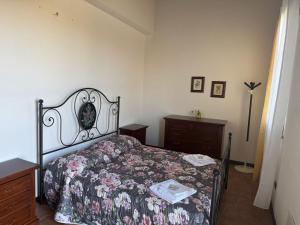 a bedroom with a bed with a floral bedspread and a dresser at Villa Cavalieri in Vedriano in Roncovetro