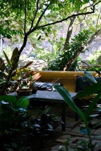 a person sitting on a bench in a garden at La Muraille, Galle Fort in Galle