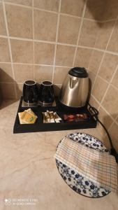 a tray with a tea kettle and a plate on a counter at Margerita in Mytilene