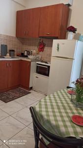 a kitchen with a white refrigerator and a table at Margerita in Mytilene