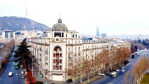 a large white building with a clock on top of it at Riverside Baratashvili Apartment in Tbilisi City