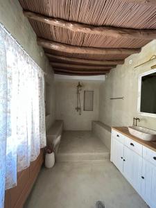 a bathroom with a tub and a sink and a shower at Floura's Kamariko - Authentic Rhodian Village House in Archangelos +20 photos