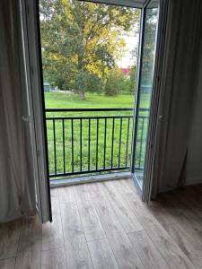 an open door to a balcony with a view at Apartament Ełcka 2- Mazury in Orzysz