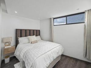 a bedroom with a large bed and a window at Casa Solis at Wild Olive in Windhoek