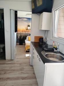 a kitchen with a sink and a view of a bedroom at Domki Letniskowe BŁĘKIT in Gąski +47 photos