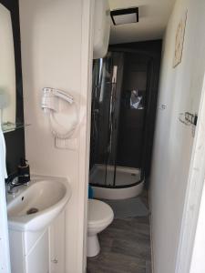 a small bathroom with a toilet and a sink at Domki Letniskowe BŁĘKIT in Gąski