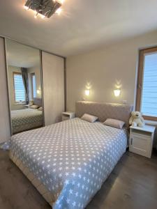 a bedroom with a large bed and a large mirror at Klaipeda Seaside Apartments with self check-in in Klaipėda