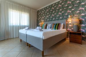 a bedroom with a large bed with a floral wall at Quinta do Pedro in Luz de Tavira +12 photos
