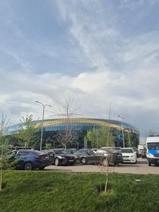 a parking lot with cars parked in front of a building at Green apple in Almaty