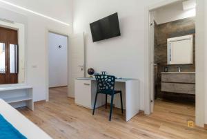 a room with a desk with a chair and a television at Identity By Rentbase in Cefalù