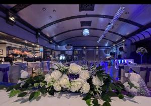 a table with a large bouquet of white flowers at Empress Boutique Hotel Suites in Mexborough