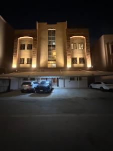 Nachts parkten zwei Autos vor einem Gebäude. in der Unterkunft Sar studio in Khobar