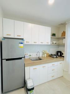 a kitchen with white cabinets and a refrigerator at Casa Augusto in Santo Tomas