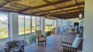 a screened in porch with chairs and a dining room at The Edge Mountain Retreat in Hogsback