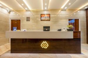 eine Lobby mit einem Empfangstresen, auf dem ein Laptop steht in der Unterkunft Marks in Noida
