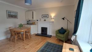 a living room with a table and a kitchen at 3 St Gilbert Street in Dornoch
