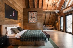 a bedroom with a bed in a room with wooden walls at Cervus Magura in Măgura
