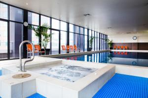 メルボルンにあるExclusive Stays - Gallery Towerのプール付きの客室で、大きなバスタブが備わります。