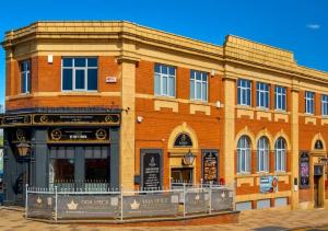 a brick building on a street in front at Empress Boutique Hotel Suites in Mexborough