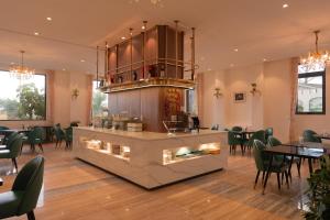 a restaurant with a bar with chairs and tables at Rung La Kim Resort in Da Lat
