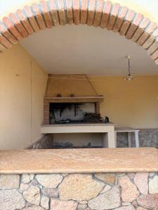 an archway in a room with a stone wall at Villa Irmā in Tertenìa