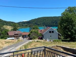 a view of a house and a road and a lake at Le Narlay in Le Frasnois