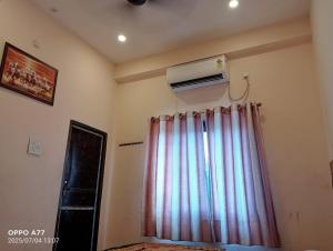 a room with a curtain and a air conditioner on the wall at Nepal VaNaVaS Retreat in Changunarayan