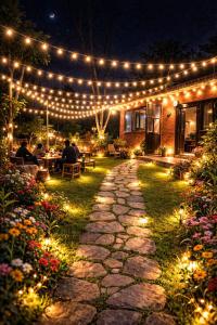 a garden with lights and a patio with people sitting at tables at Nepal VaNaVaS Retreat in Changunarayan