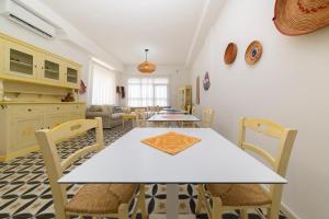 a dining room with a white table and chairs at NG Guest House Ammentos in Olbia