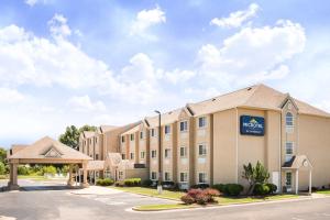 un hôtel avec un panneau à l'avant d'un bâtiment dans l'établissement Microtel Inn & Suites Claremore, à Claremore