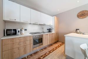 a kitchen with wooden cabinets and a stove top oven at Blizzard apartments Kevin in Arabba