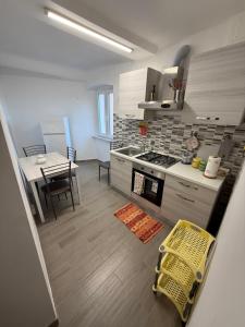 a kitchen and dining room with a table and a yellow chair at Appartamento LUNA in Mele